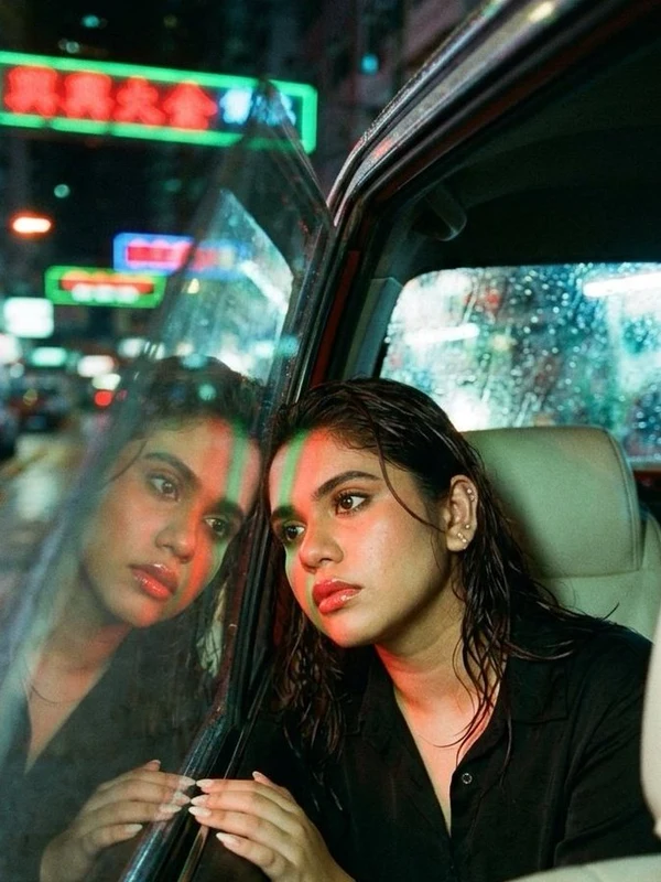 Woman seated inside a taxi on a rainy night